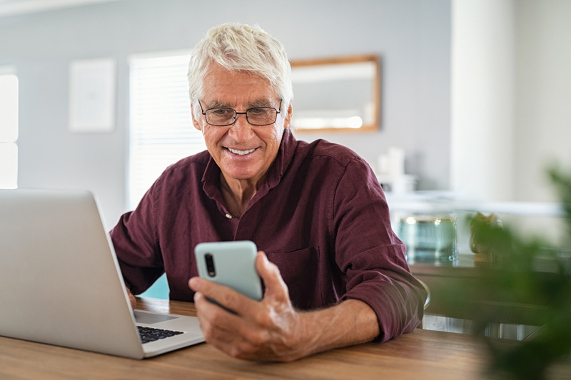 Senior man using laptop and smart phone